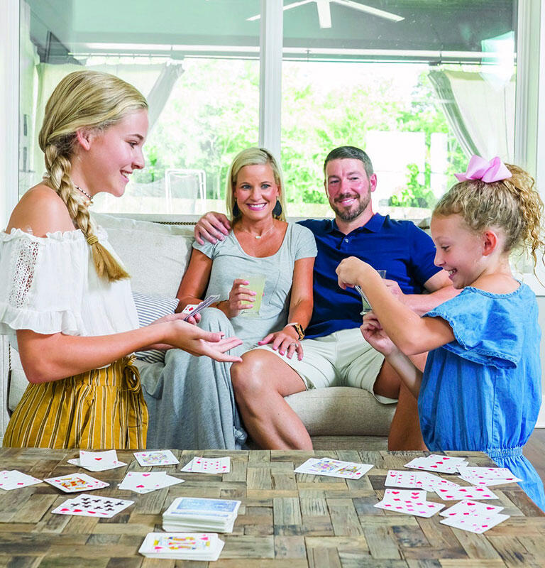 children playing card as parents watch